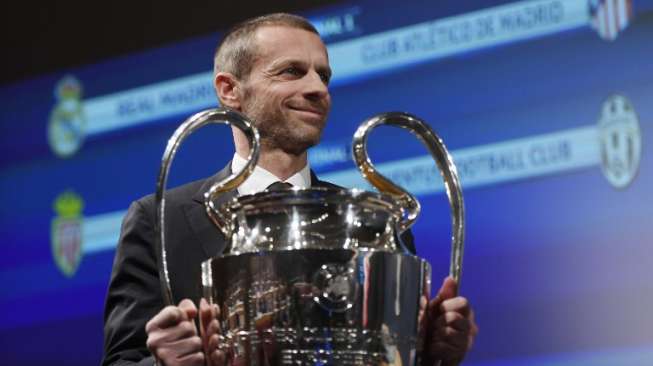 Presiden UEFA Aleksander Ceferin membawa trofi Liga Champions usai acara drawing semifinal yang berlangsung di Nyon [AFP]