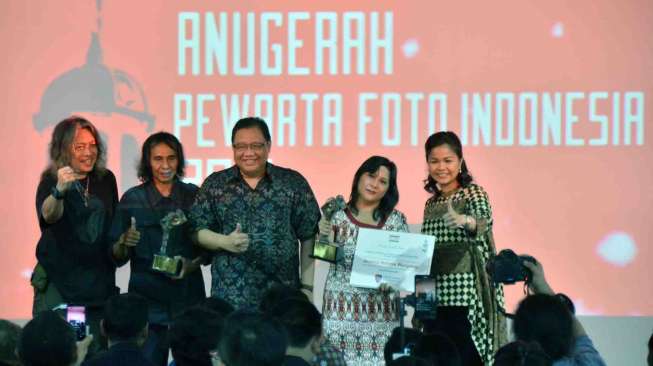 Menteri Koperasi dan UKM Anak Agung Gede Ngurah Puspayoga (tengah) bersama anggota Dewan juri Oscar Motuloh (kiri) mendampingi peraih "Life Time Achievement" pewarta foto Serambi Indonesia Bedu Saini (kedua kiri) bersama peraih "Photo of the Year" pewarta Antara Foto Jessica Helena Wusyang (kedua kanan) saat acara Anugerah Pewarta Foto Indonesia (APFI) 2017 di Galeria Fatahillah, Jakarta, Jumat (21/4).