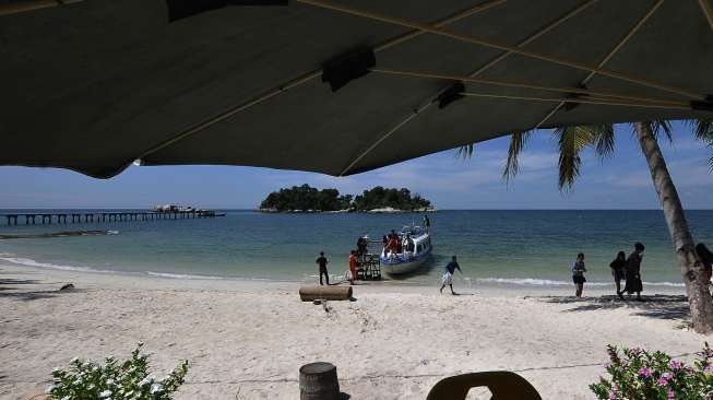 Pengunjung menuruni kapal di dermaga darurat Pulau Berhala, Lingga, Kepulauan Riau, Minggu (23/4/2017), dalam rangka mengisi libur panjang akhir pekan. [Antara/Wahdi Septiawan]