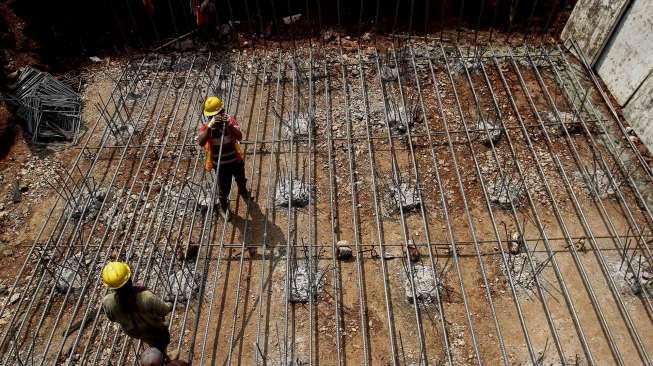 Pekerja tampak memasang rangka baja untuk membuat tiang pondasi pembangunan proyek Tol Becakayu di Kalimalang, Jakarta, Senin (24/4/2017). [Suara.com/Kurniawan Mas'ud]