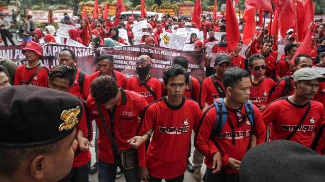 Aksi ratusan buruh yang tergabung dalam Federasi Serikat Buruh Karya Utama (FSBKU) ketika melakukan aksi unjuk rasa di depan gedung Kementerian BUMN di Jakarta, Kamis (27/4/2017). [Suara.com/Kurniawan Mas'ud]