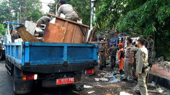 Dengan bantuan alat berat (Beko), petugas Satpol PP merubuhkan bangunan liar di Jalan Anyer, Menteng, Jakarta, Jumat (28/4/2017). [Suara.com/Oke Atmaja]