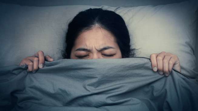 Ilustrasi seorang perempuan tak bisa tidur nyenyak karena mimpi buruk. (Shutterstock)