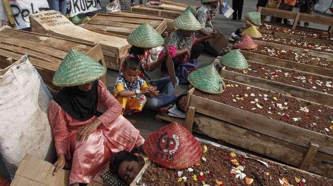 Puluhan anak usia 10-14 tahun warga Teluk Jambe melakukan aksi kubur diri di depan Istana Merdeka, Jakarta, Selasa (2/5).