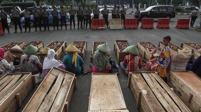 Puluhan anak usia 10-14 tahun warga Teluk Jambe melakukan aksi kubur diri di depan Istana Merdeka, Jakarta, Selasa (2/5).