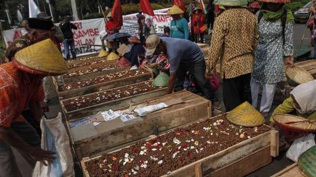 Puluhan anak usia 10-14 tahun warga Teluk Jambe melakukan aksi kubur diri di depan Istana Merdeka, Jakarta, Selasa (2/5).