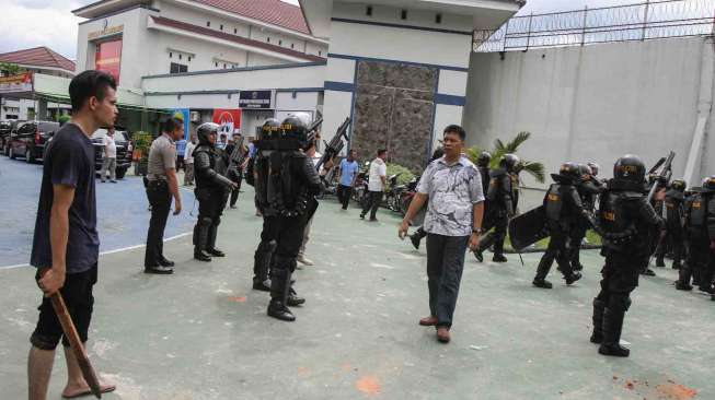 Petugas kepolisian berpakaian sipil dibantu warga menangkap tahanan yang kabur dari Rutan Sialang Bungkuk Kelas IIB, Pekanbaru, Riau, Jumat (5/5).
