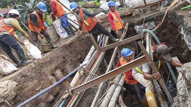 Pekerja melakukan perawatan saluran air bersih di kawasan Gatot Subroto, Jakarta, Kamis (5/5).