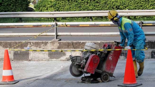 Seorang pekerja tampak menyelesaikan perbaikan jalur Transjakarta di Jalan Gatot Subroto, Jakarta, Sabtu (6/5/2017). [Suara.com/Oke Atmaja]