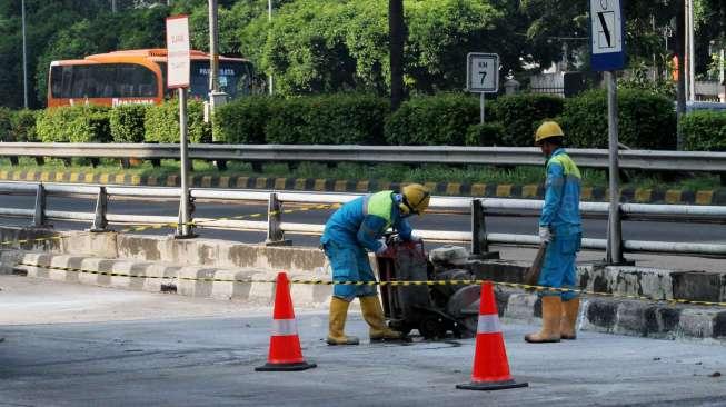 Pekerja tampak menyelesaikan perbaikan jalur Transjakarta di Jalan Gatot Subroto, Jakarta, Sabtu (6/5/2017). [Suara.com/Oke Atmaja]