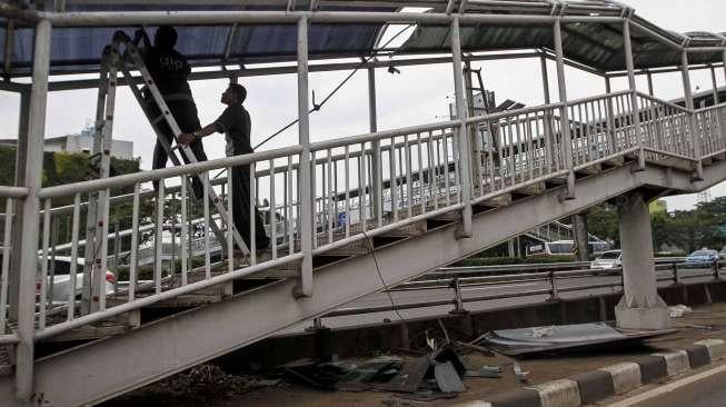 Petugas melakukan perbaikan atap kanopi halte  Transjakarta di Pancoran Barat, Jakarta, Kamis (11/5).