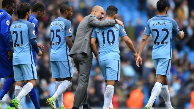 Manajer Manchester City Pep Guardiola (tengah) berbicara dengan striker Sergio Aguero setelah menang 2-1. Anthony DEVLIN / AFP