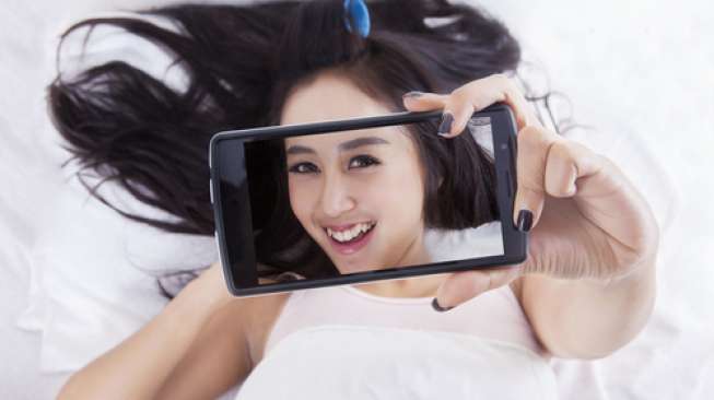 Ilustrasi perempuan sedang selfie. (Shutterstock)