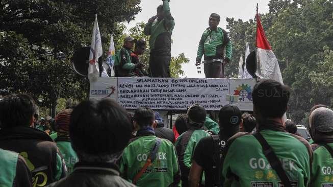 Pengemudi ojek online berunjuk rasa dengan berjalan kaki dari bundaran 'Patung Kuda' menuju Gedung Kementerian Perhubungan, Jakarta, Senin (15/5).