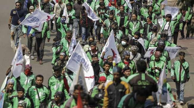 Pengemudi ojek online berunjuk rasa dengan berjalan kaki dari bundaran 'Patung Kuda' menuju Gedung Kementerian Perhubungan, Jakarta, Senin (15/5).