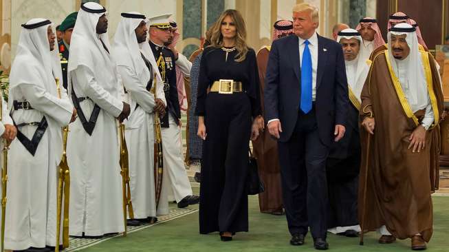 Presiden Amerika Serikat (AS) Donald Trump dan istrinya Melania Trump didampingi Raja Arab Saudi Salman bin Abdulaziz al-Saud, saat tiba di Pengadilan Kerajaan Saudi di Riyadh, Sabtu (20/5/2017). [Bandar al-Jaloud/Saudi Royal Palace/AFP]