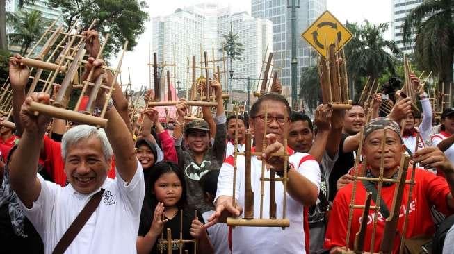 Menkominfo Rudiantara bermain angklung dalam rangka memperingati Hari Kebangkitan Nasional, Minggu [21/5/2017]. [suara.com/Oke Atmaja]