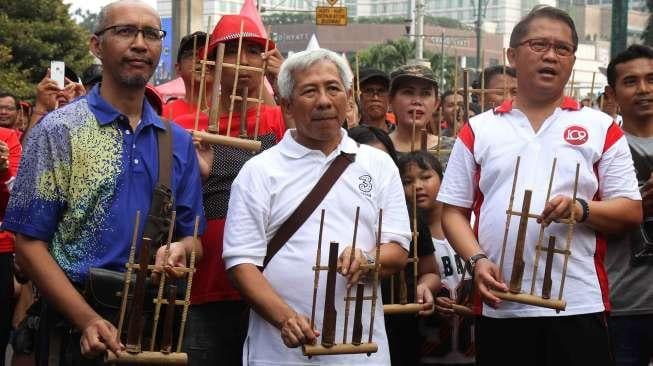 Menkominfo Rudiantara bermain angklung dalam rangka memperingati Hari Kebangkitan Nasional, Minggu [21/5/2017]. [suara.com/Oke Atmaja]