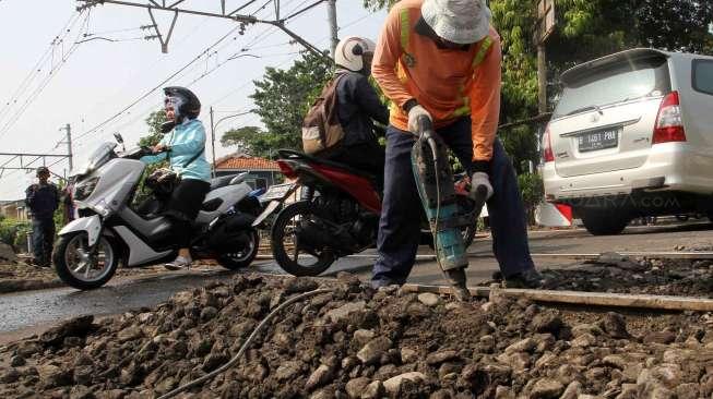 Pekerja tampak memperbaiki jalur rel kereta api yang ambles di jalur KRL Manggarai-Sudirman di Jakarta, Selasa (23/5/2017). [Suara.com/Oke Atmaja]