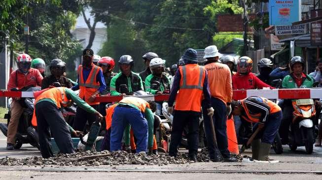 Sejumlah pekerja memperbaiki jalur rel kereta api yang ambles di jalur KRL Manggarai-Sudirman di Jakarta, Selasa (23/5/2017). [Suara.com/Oke Atmaja]