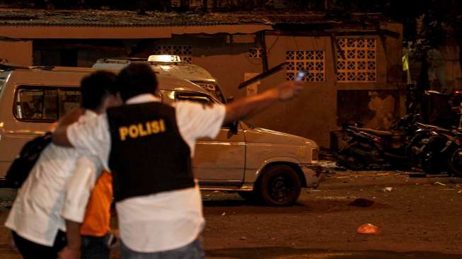 Personil Gegana Brimob Polda Metro Jaya melakukan penyisiran di lokasi ledakan yang diduga bom di Terminal Kampung Melayu, Jakarta Timur, Rabu (24/5) malam. Sementara anggota polisi lainnya mengamankan sekitar lokasi [Suara.com/Kurniawan Mas'ud]