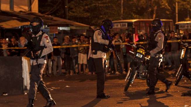 Personil Gegana Brimob Polda Metro Jaya melakukan penyisiran di lokasi ledakan yang diduga bom di Terminal Kampung Melayu, Jakarta Timur, Rabu (24/5) malam. Sementara anggota polisi lainnya mengamankan sekitar lokasi [Suara.com/Kurniawan Mas'ud]