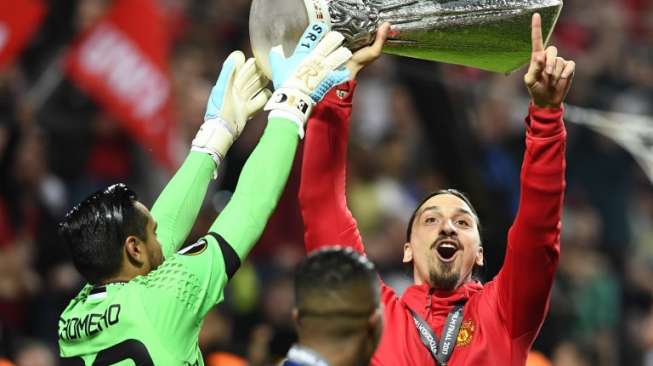 Zlatan Ibrahimovic mengangkat trofi Liga Europa usai MU mengalahkan Ajax di babak final [AFP]