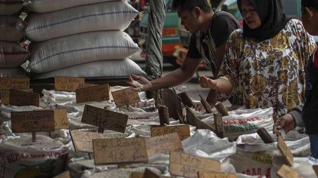 Calon pembeli memilih jenis beras yang dijual pedagang di pasar induk beras Cipinang, Jakarta, Senin (29/5).