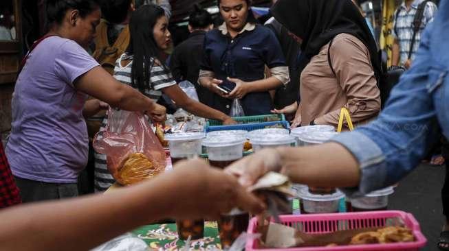 Warga dan para karyawan membeli makanan atau takjil untuk berbuka puasa di kawasan Kebon Kacang, Jakarta, Senin (29/5).