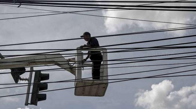 Petugas memperbaiki rambu lampu lalu lintas di kawasan Otista, Jakarta, Rabu (31/5).