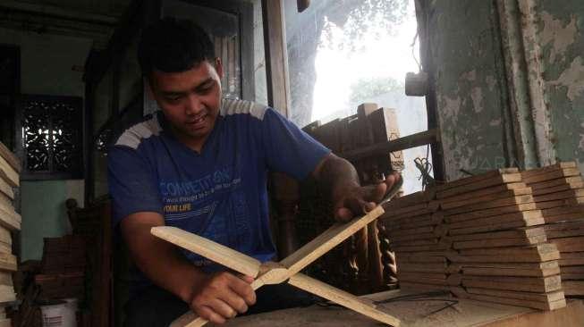 Pekerja menyelesaikan pembuatan rekal Al Quran atau tatakan untuk membaca Al Quran di kawasan Klender, Jakarta, Selasa (6/6).