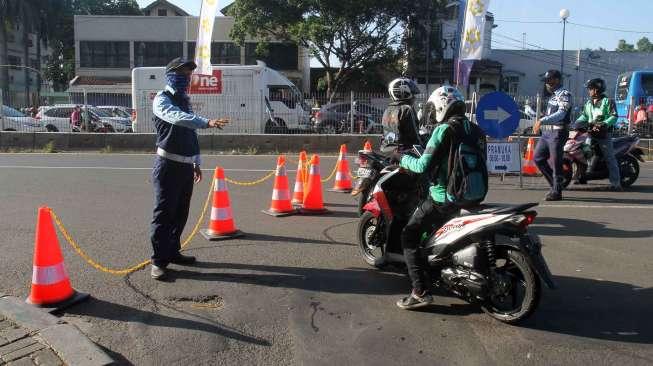 Petugas terlihat mengarahkan kendaraan bermotor di kawasan Jalan Matraman, Jakarta, saat dilakukan rekayasa lalu lintas, Kamis (8/6/2017). [Suara.com/Oke Atmaja]