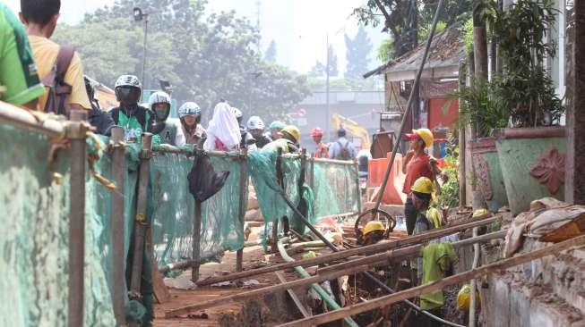 Sejumlah pekerja menyelesaikan pembangunan saluran air di kawasan Mampang, Jakarta, Senin (12/6).