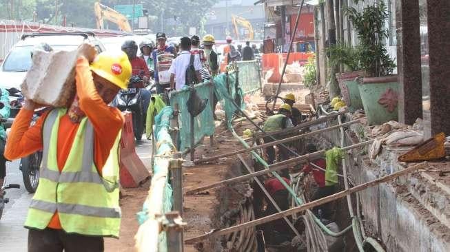 Sejumlah pekerja menyelesaikan pembangunan saluran air di kawasan Mampang, Jakarta, Senin (12/6).