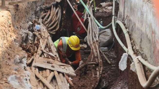 Sejumlah pekerja menyelesaikan pembangunan saluran air di kawasan Mampang, Jakarta, Senin (12/6).