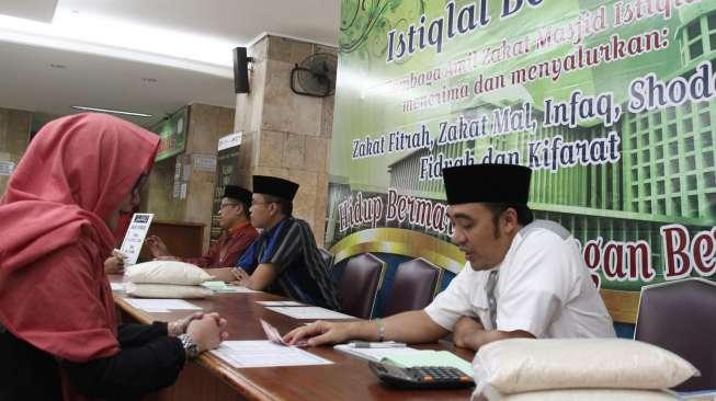 Warga terlihat melakukan pembayaran zakat fitrah melalui lembaga amil zakat di Masjid Istiqlal, Jakarta, Kamis (22/6/2017). [Suara.com/Oke Atmaja]
