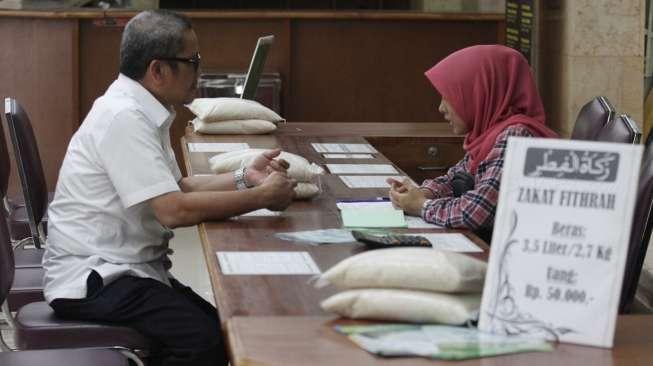Salah seorang warga saat melakukan pembayaran zakat fitrah melalui lembaga amil zakat di Masjid Istiqlal, Jakarta, Kamis (22/6/2017). [Suara.com/Oke Atmaja]