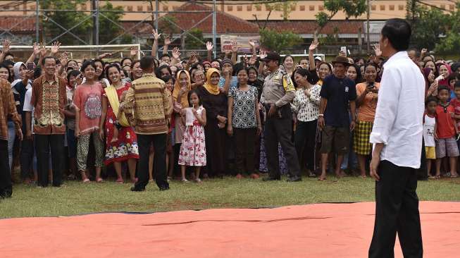 Presiden Joko Widodo membagikan paket sembako kepada warga di kawasan Duri Kepa, Jakarta, Kamis (22/6).