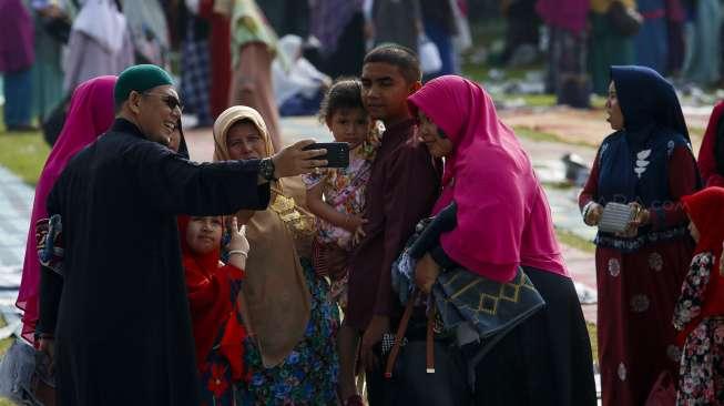 Ribuan umat muslim melaksanakan Salat Idul Fitri 1438 Hijriah di Lapangan Merdeka, Kota Solok, Sumatera Barat, Minggu (25/6). [Suara.com/Kurniawan Mas'ud]