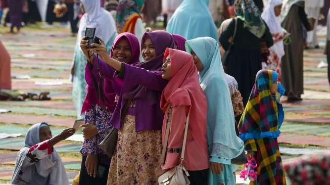 Ribuan umat muslim melaksanakan Salat Idul Fitri 1438 Hijriah di Lapangan Merdeka, Kota Solok, Sumatera Barat, Minggu (25/6). [Suara.com/Kurniawan Mas'ud]