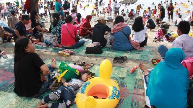 Pengunjung bermain di Pantai Ancol, Jakarta, Rabu (28/6). (Suara.com/Oke Atmaja)