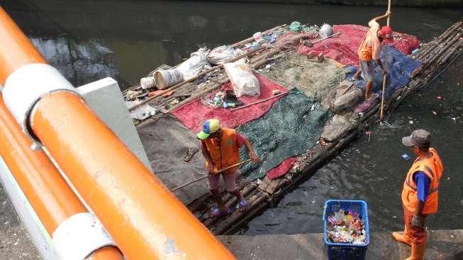 Petugas Dinas Kebersihan DKI Jakarta membersihkan sampah di Kali Tanah Abang, Jakarta, Jumat (30/6).
