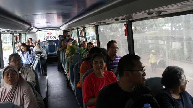 Warga mengantre untuk naik bus tingkat keliling Jakarta di Halte Lapangan IRTI, Jakarta, Sabtu (1/7).