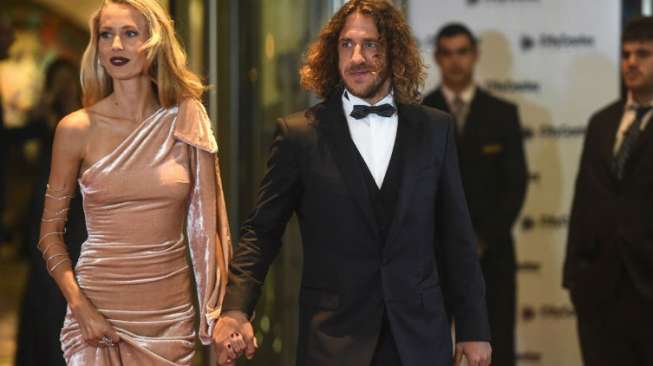 Mantan pemain Barcelona Carles Puyol bersama isteri [AFP]