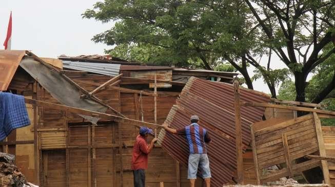 Warga tampak membongkar bangunan miliknya masing-masing di wilayah bantaran Sungai Ciliwung, Bukit Duri, Jakarta, Sabtu (8/7/2017). [Suara.com/Oke Atmaja]