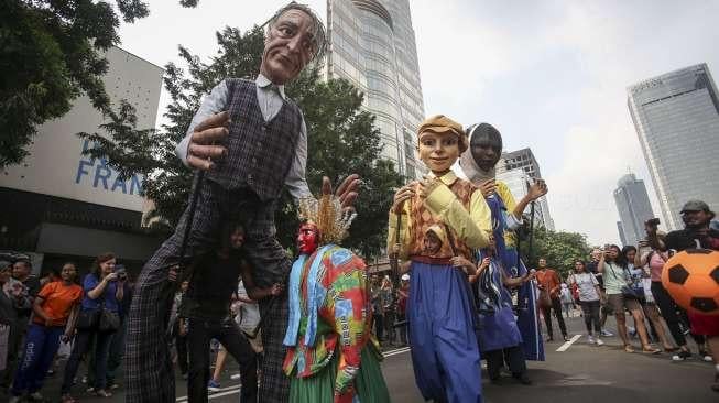 Empat boneka asal Prancis dari Kelompok teater Les Grandes Personnes hibur warga saat berlangsungnya Car Free Day (CFD) di Jakarta, Minggu (9/7). [Suara.com/Kurniawan Mas'ud]