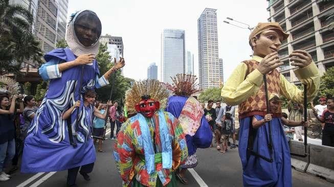 Empat boneka asal Prancis dari Kelompok teater Les Grandes Personnes hibur warga saat berlangsungnya Car Free Day (CFD) di Jakarta, Minggu (9/7). [Suara.com/Kurniawan Mas'ud]