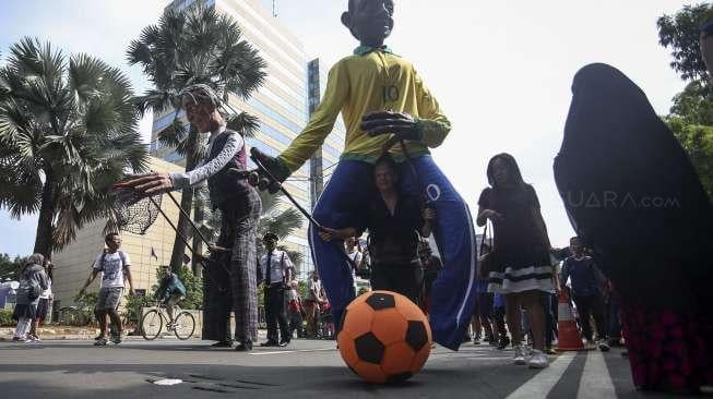 Empat boneka asal Prancis dari Kelompok teater Les Grandes Personnes hibur warga saat berlangsungnya Car Free Day (CFD) di Jakarta, Minggu (9/7). [Suara.com/Kurniawan Mas'ud]