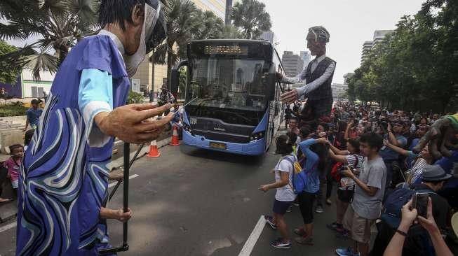 Empat boneka asal Prancis dari Kelompok teater Les Grandes Personnes hibur warga saat berlangsungnya Car Free Day (CFD) di Jakarta, Minggu (9/7). [Suara.com/Kurniawan Mas'ud]