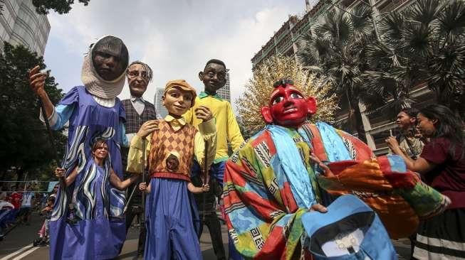 Empat boneka asal Prancis dari Kelompok teater Les Grandes Personnes hibur warga saat berlangsungnya Car Free Day (CFD) di Jakarta, Minggu (9/7). [Suara.com/Kurniawan Mas'ud]